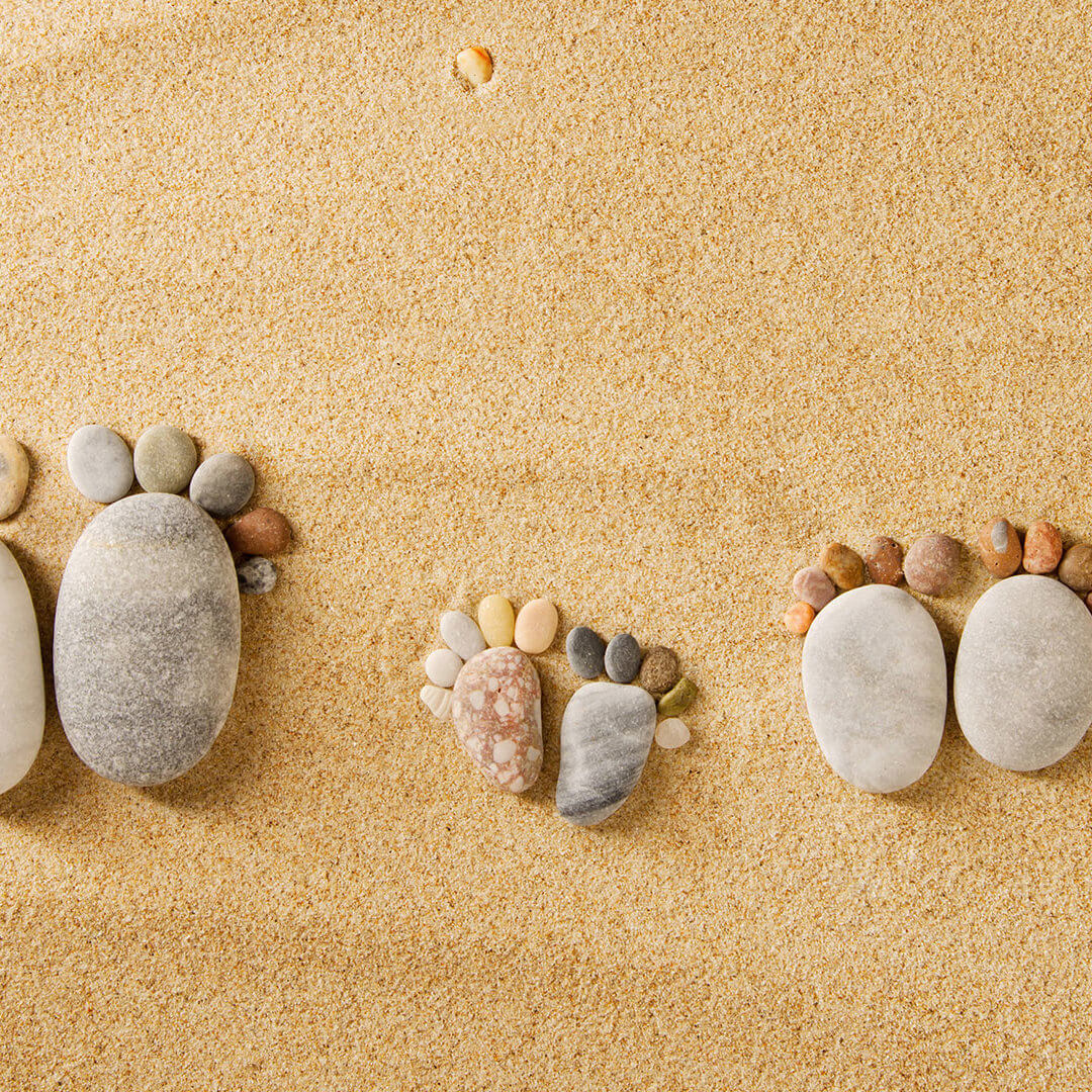 Pieds formés avec des galets colorés sur du sable