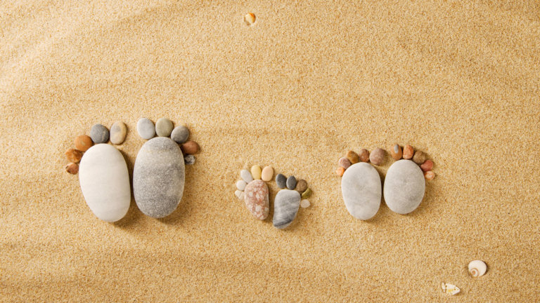 Pieds formés avec des galets colorés sur du sable